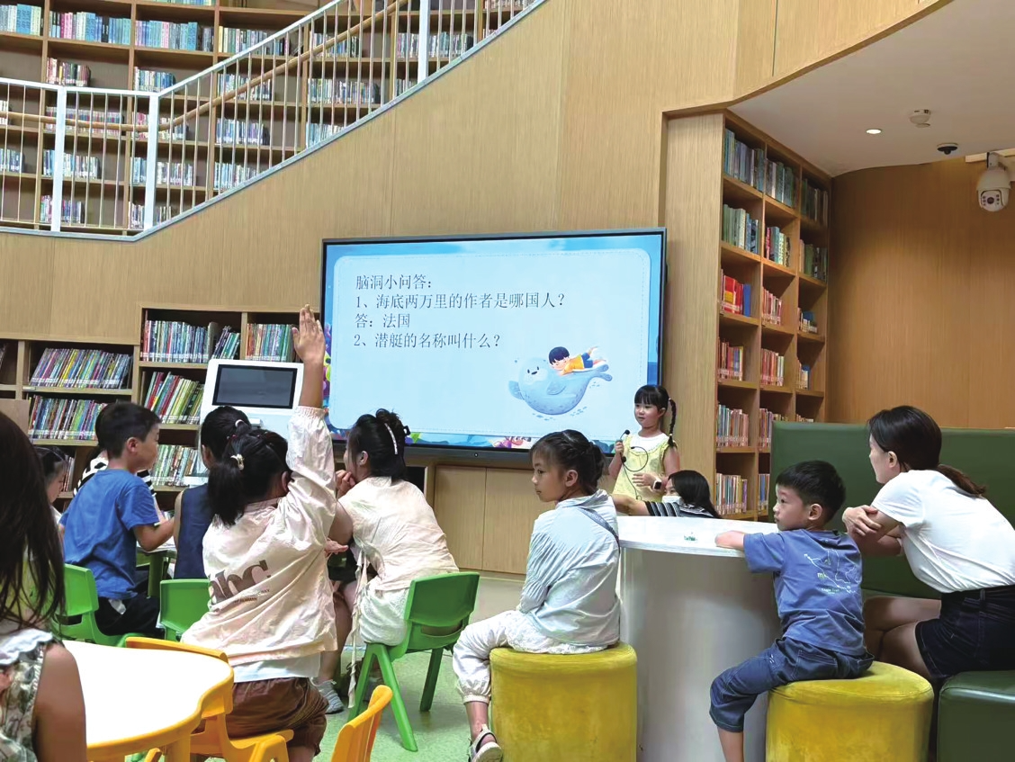 市图书馆分享会上,孩子们举手回答问题。